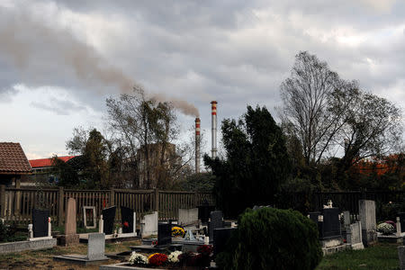 Smoke rising from a chimney of cement factory is seen from a cemetery in the village of Lukavac near Tuzla, Bosnia, October 30, 2018. REUTERS/Marko Djurica/Files