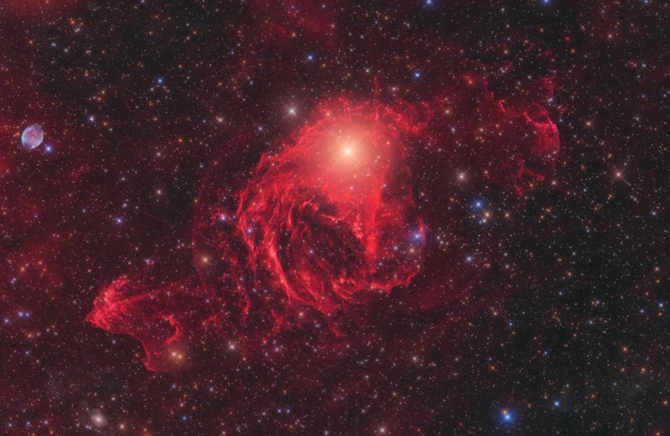 Red galactic nebula shines against a background of stars