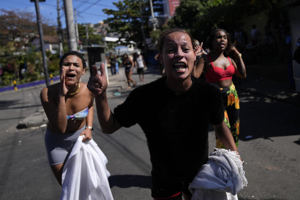 Residents shout at police in protest against a police operation that resulted in multiple deaths, in the Complexo do Alemao favela in Rio de Janeiro, Brazil, Thursday, July 21, 2022. Police said in a statement it was targeting a criminal group in Rio largest complex of favelas, or low-income communities, that stole vehicles, cargo and banks, as well as invaded nearby neighborhoods. (AP Photo/Silvia Izquierdo)