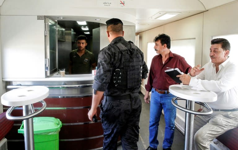 A member of the Iraqi forces stands near the refreshments bar in the dining carriage on the train from Baghdad to Fallujah, which passengers find a welcome alternative to polluted and gridlocked roads