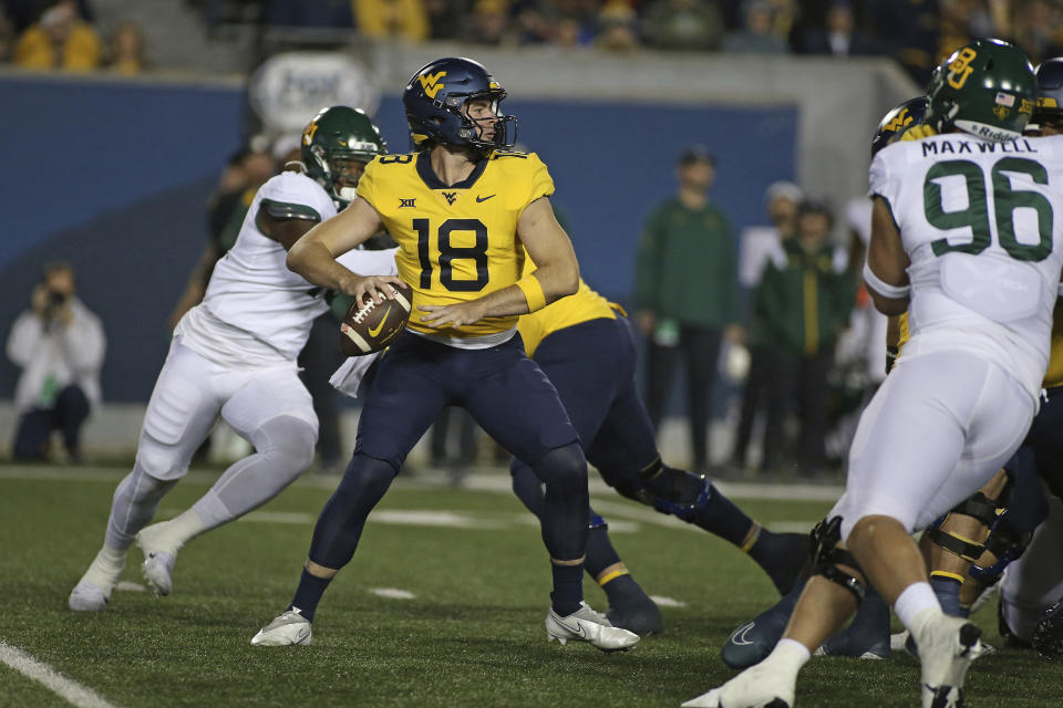 West Virginia quarterback JT Daniels (18) looks for a receiver during the first half of the team's NCAA college football game against Baylor in Morgantown, W.Va., Thursday, Oct. 13, 2022. (AP Photo/Kathleen Batten)