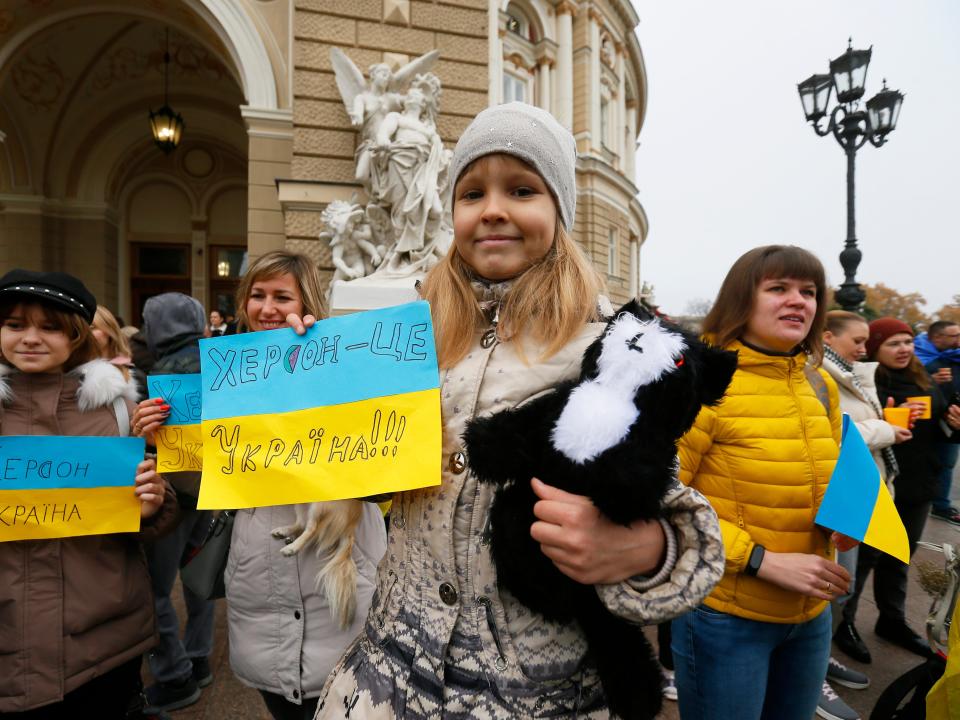 Kherson residents temporarily living in Odesa holding national flags and placards celebrate the liberation of their native town in Odesa on 12 November 2022, amid Russia's invasion of Ukraine.