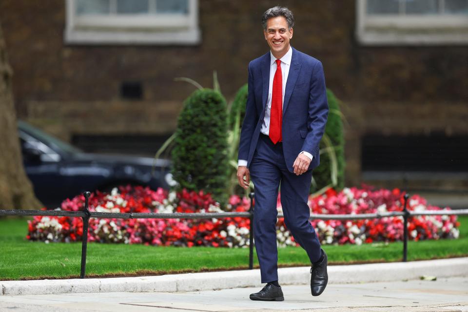 Ed Milliband grins as he walks along Downing Street to No 10 (REUTERS)
