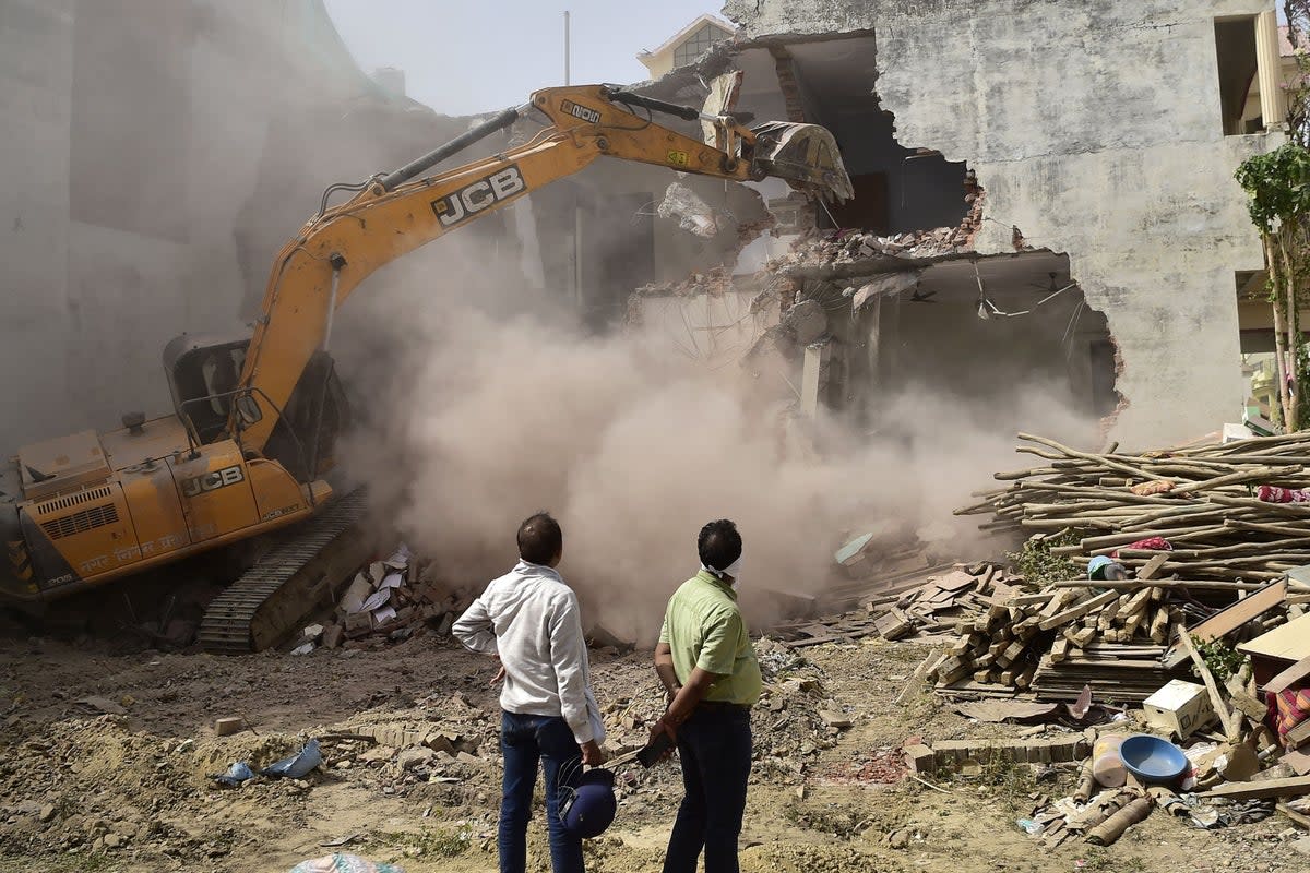 In this file photo taken on 12 June 2022, a bulldozer demolishes the house of a local leader allegedly involved in recent violent protests against Bharatiya Janata Party’s (BJP) former spokesperson Nupur Sharma's incendiary remarks about Prophet Mohammed in Allahabad (AFP via Getty Images)