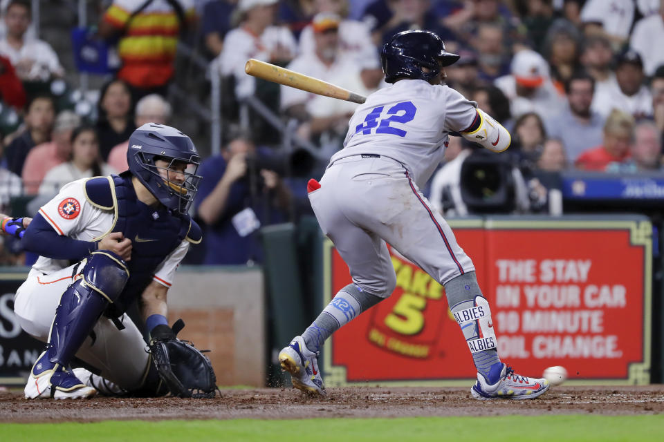 With the bases loaded, Atlanta Braves batter Ozzie Albies, right, is hit in the foot by a pitch in front of Houston Astros catcher Yainer Diaz, left, allowing the Braves' second run during the second inning of a baseball game Monday, April 15, 2024, in Houston. (AP Photo/Michael Wyke)