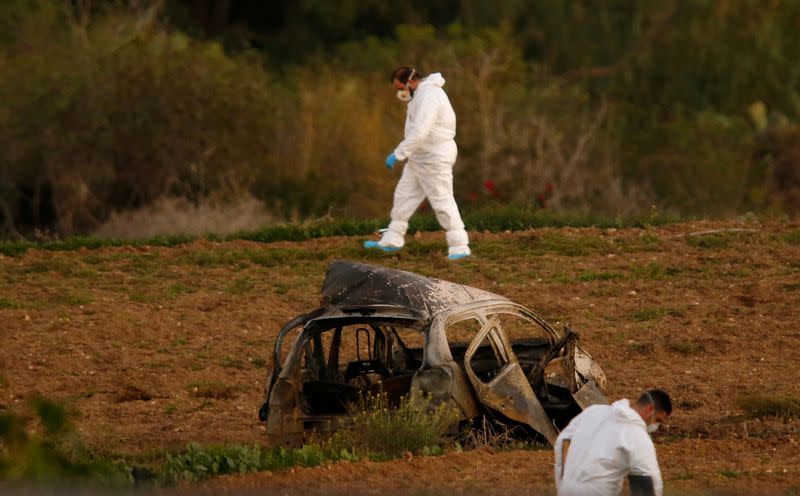 FILE PHOTO: Forensic experts walk in a field after a powerful bomb blew up a car killing investigative journalist Daphne Caruana Galizia in Bidnija