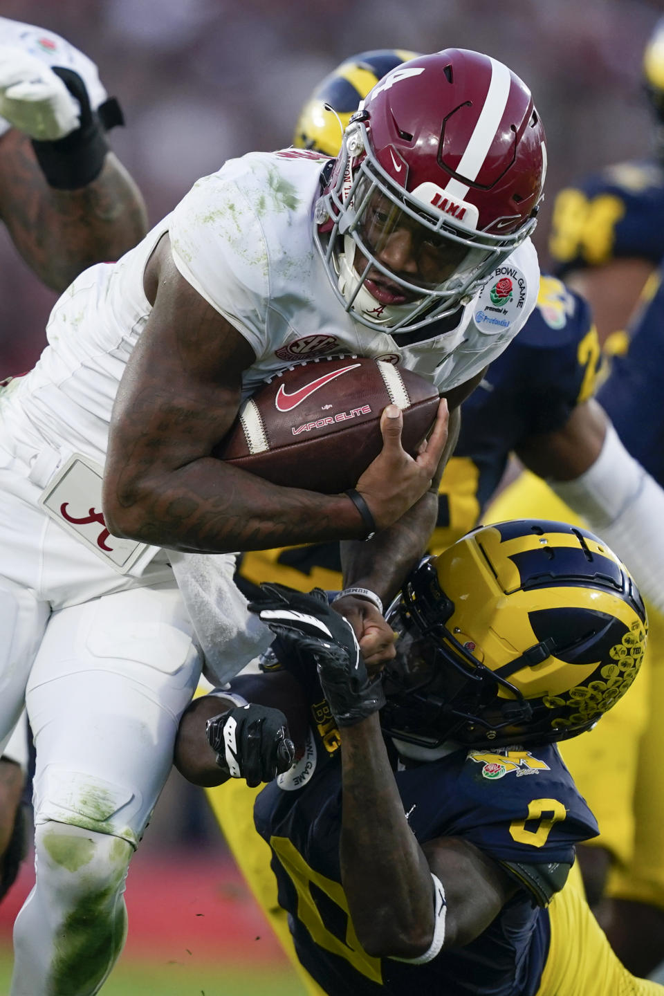 Alabama quarterback Jalen Milroe, top, is tackled by Michigan defensive back Mike Sainristil (0) during the second half in the Rose Bowl CFP NCAA semifinal college football game Monday, Jan. 1, 2024, in Pasadena, Calif. (AP Photo/Ryan Sun)