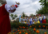 Members of a local community center wear traditional Ukrainian clothing to record an online video message for the country's upcoming Independence Day on Aug. 24 in Andriivka, Donetsk region, eastern Ukraine, Friday, Aug. 19, 2022. (AP Photo/David Goldman)