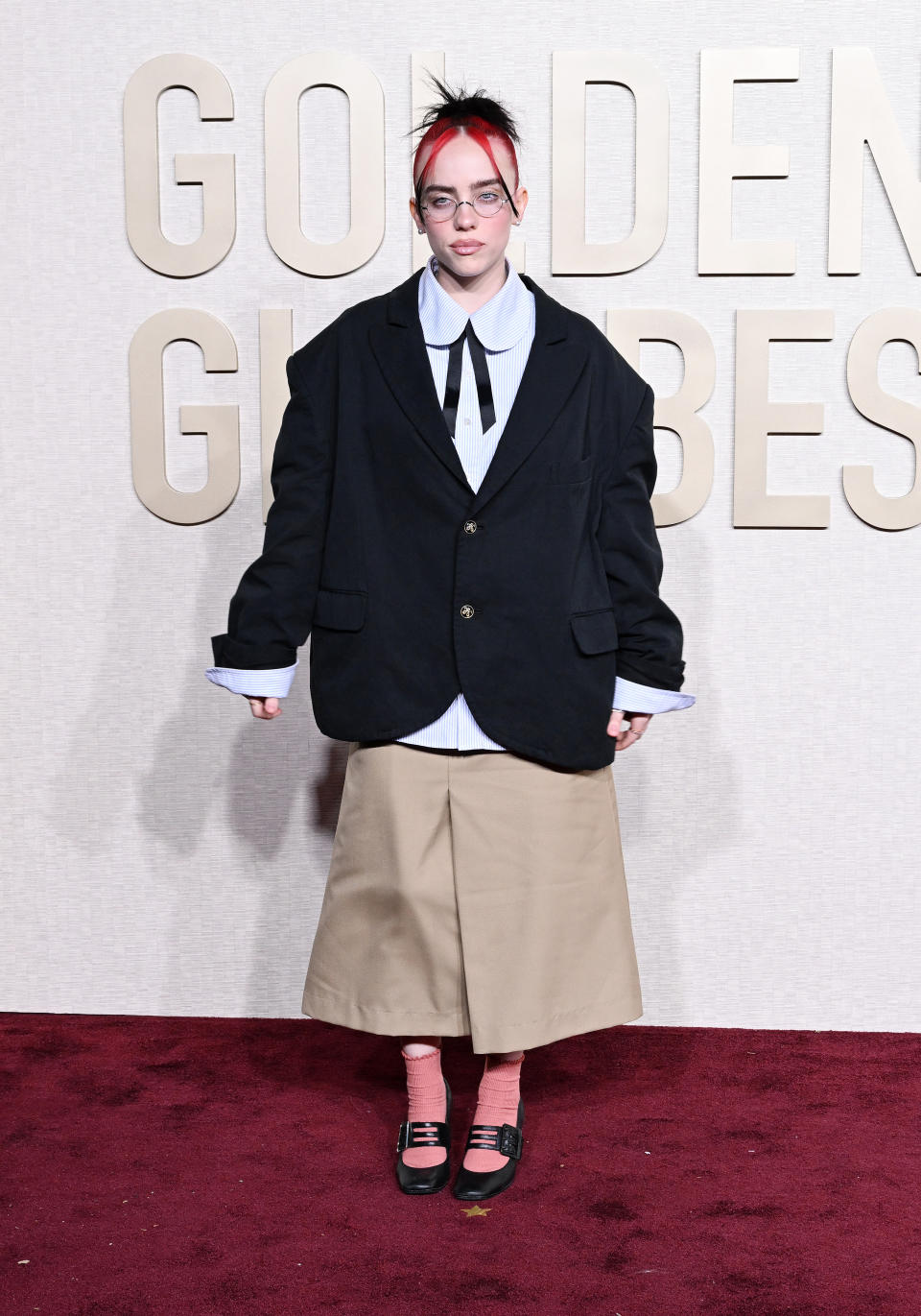 Billie Eilish wore a collegiate-inspired look by Willy Chavarria to the 81st Golden Globe Awards. (Image via Getty Images)