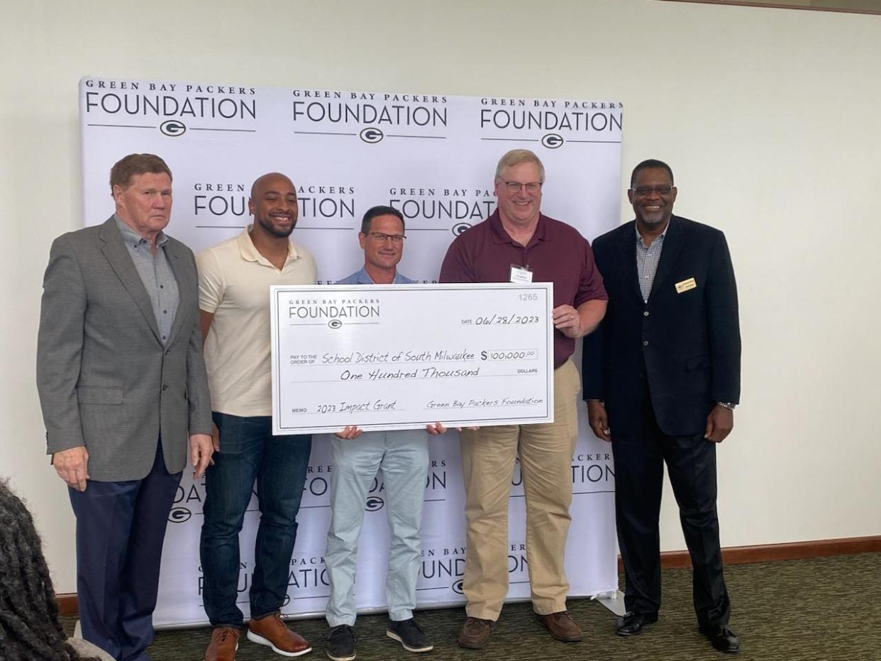 Launching a Legacy co-chair Jeffery Dess (middle) and South Milwaukee Football Booster President and Launching a Legacy Committee Member Tom Spaltholz (to the right of Dess) accept a 2023 Impact Grant check from the Green Bay Packers Foundation.