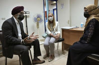 Canadian Minister of International Development Harjit Sajjan, left, speaks with a Syrian refugee woman during his visit with the Canadian Ambassador to Lebanon Chantal Chastenay, center, to Makassed primary health care center, in Beirut, Lebanon, Wednesday, Aug. 17, 2022. Sajjan said Syria is not safe yet for millions of refugees to start returning home and those who fled their homes did so only because they had to. He also said , he also said that Lebanon should work to reach a deal with the International Monetary Fund to start getting the small nation out its worst economic crisis in its modern history. (AP Photo/Hussein Malla)