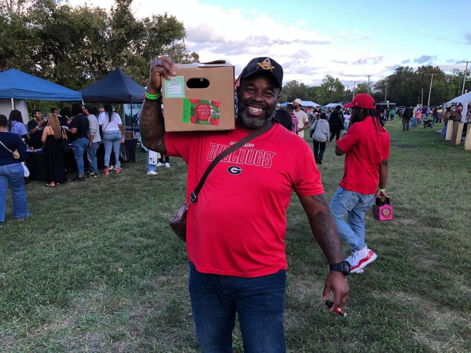 Darius Christian of Suffolk totes a variety of craft beer, cider, mead and wine he purchased at the 2023 Festival of Grapes and Hops in Petersburg.