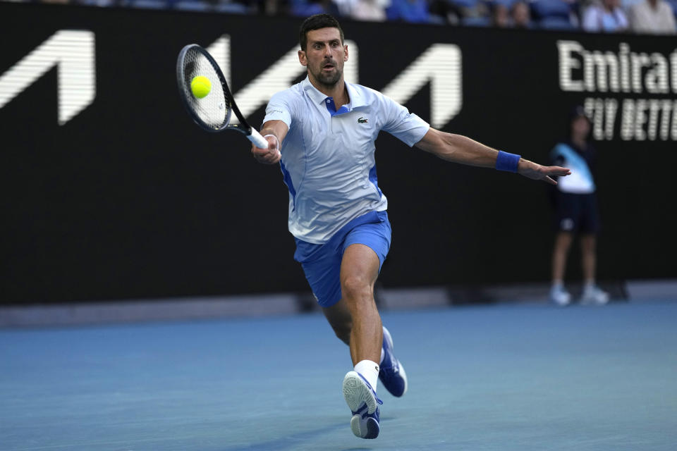 Novak Djokovic of Serbia plays a forehand return to Taylor Fritz of the U.S. during their quarterfinal match at the Australian Open tennis championships at Melbourne Park, Melbourne, Australia, Tuesday, Jan. 23, 2024. (AP Photo/Louise Delmotte)