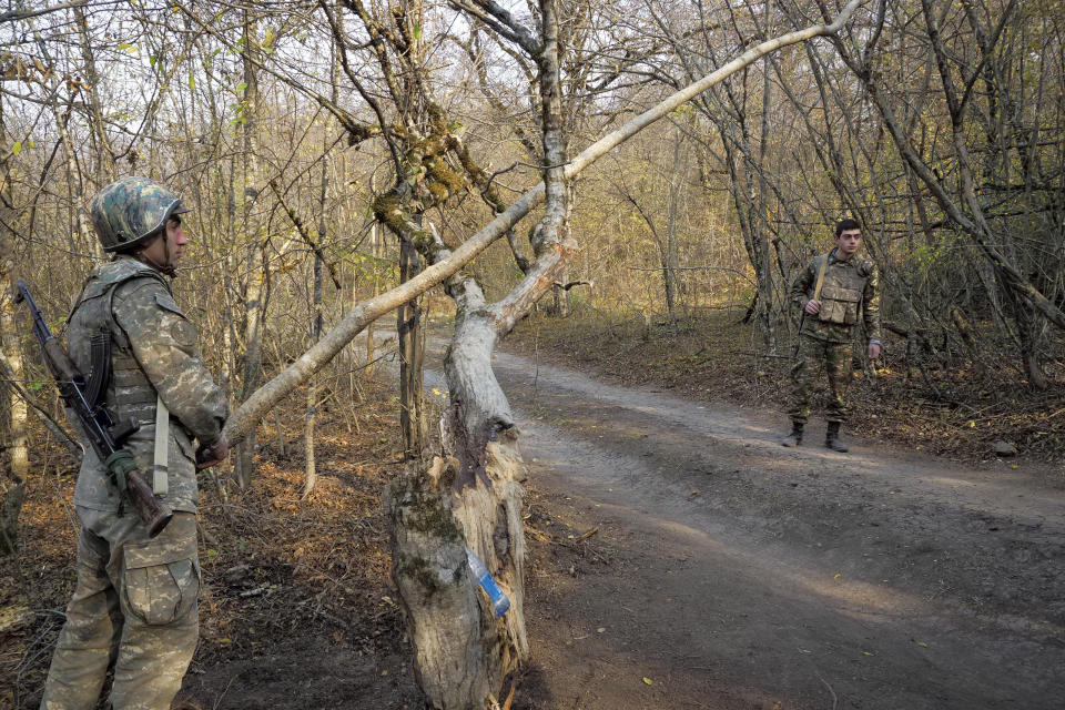 An ethnic Armenian soldier opens the barrier at the checkpoint near the front line during a military conflict in separatist region of Nagorno-Karabakh, Monday, Nov. 2, 2020. Fighting over the separatist territory of Nagorno-Karabakh entered sixth week on Sunday, with Armenian and Azerbaijani forces blaming each other for new attacks. (AP Photo)