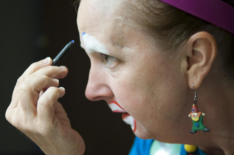 In a July 31, 2012 photo, Laura Sicklesteel, or "Molly the Clown" puts on makeup while getting into character at the third annual Clown Campin' in Ontario, Calif. The week long event is held for clowns across the United States and Canada to learn, get inspired, and network. (AP Photo/Grant Hindsley)