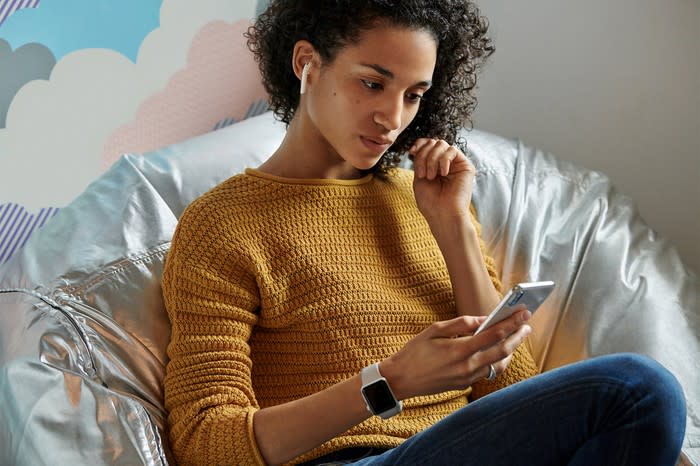 Woman wearing AirPods using an iPhone