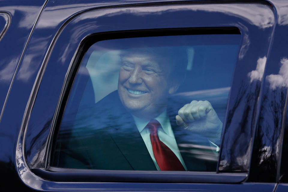 Outgoing US President Donald Trump waves to supporters lined along on the route to his Mar-a-Lago estate in West Palm Beach, Florida. 