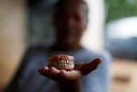 Miriam Marquez shows a dental prosthesis of her mother in law killed by Salvadorean soldiers in the village of El Mozote