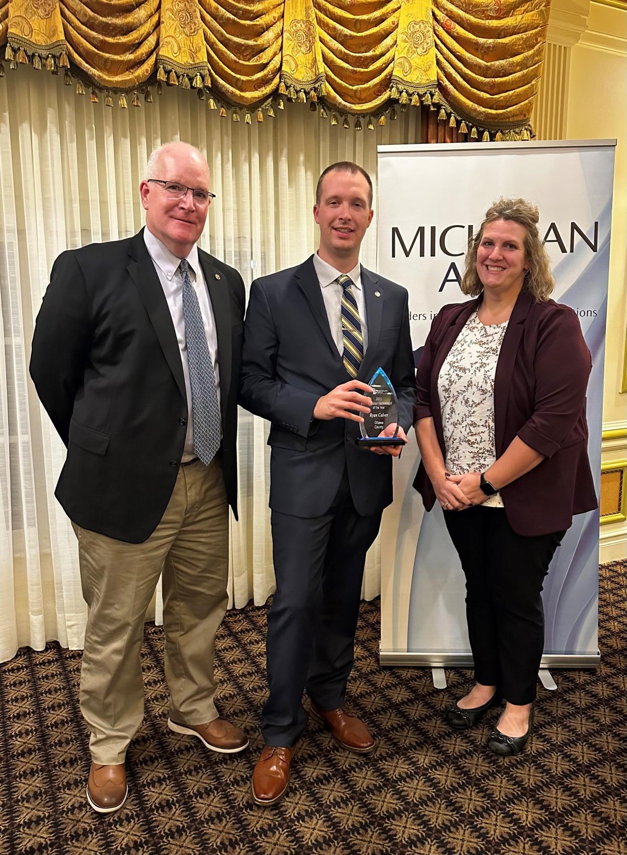 OCCDA Executive Director Pete McWatters (left) with Ryan Culver and Deputy Director Tammy Smith at the Michigan APCO Annual Meeting.