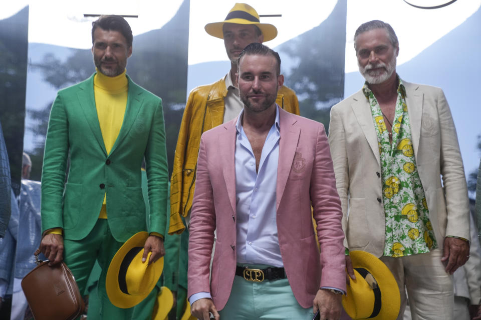 Designer, Philipp Plein, centre stands with models wearing creations as part of the Billionaire men's Spring Summer 2023 collection presented in Milan, Italy, Friday, June 17, 2022. (AP Photo/Luca Bruno)