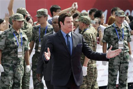 Actor John Travolta of the U.S. gestures to fans as he arrives for the launch ceremony of the Qingdao Oriental Movie Metropolis on the outskirts of Qingdao, Shandong province September 22, 2013. REUTERS/Jason Lee