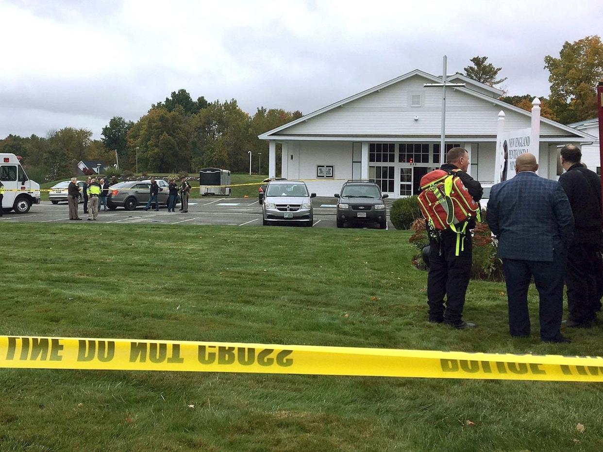 In this photo provided by WMUR-TV, police stand outside the New England Pentecostal Church after a shooting during a wedding on Saturday, 12 October 2019, in Pelham, New Hampshire: Siobhan Lopez/WMUR-TV via AP