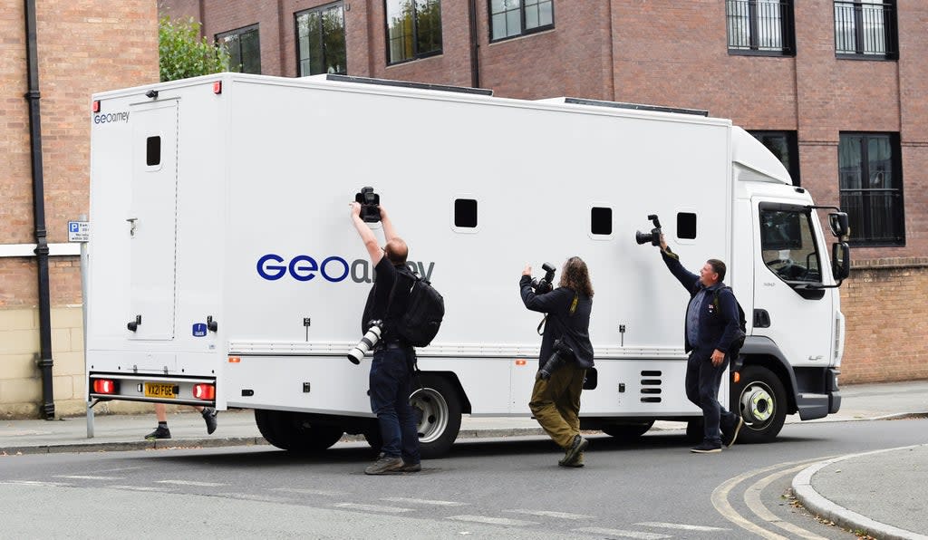 Photographers take pictures through the windows of a prison van carrying Manchester City footballer Benjamin Mendy as it leaves Chester Magistrates’ Court, Chester in August (PA) (PA Wire)