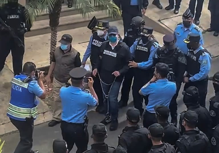 La policía escolta al expresidente de Honduras Juan Orlando Hernández (c) al salir de su casa en Tegucigalpa tras recibirse la orden de extradición de Estados Unidos, el 15 de febrero de 2022 (-)