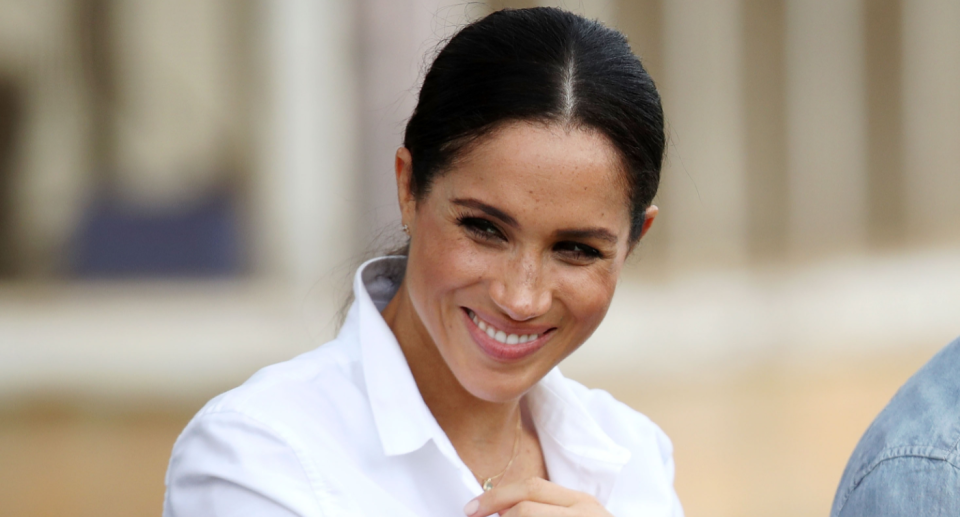 meghan markle with hair in pony smiling in white shirt, Meghan Markle's Everlane shirt is a steal at $122 (Photo via Getty)