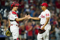 Philadelphia Phillies relief pitcher Ranger Suarez, right, celebrates the win with catcher J.T. Realmuto, left, following the ninth inning of a baseball game against the Atlanta Braves, Friday, July 23, 2021, in Philadelphia. The Phillies won 5-1. (AP Photo/Chris Szagola)