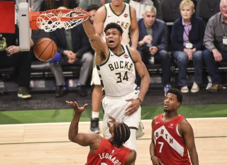 May 23, 2019; Milwaukee, WI, USA; Milwaukee Bucks forward Giannis Antetokounmpo (34) dunks the ball past Toronto Raptors forward Kawhi Leonard (2) and guard Kyle Lowry (7) in the third quarter in game five of the Eastern conference finals of the 2019 NBA Playoffs at Fiserv Forum. Mandatory Credit: Benny Sieu-USA TODAY Sports