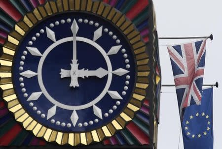 The British Union flag and the European Union flag are seen flying behind a clock in the City of London, Britain, January 16 , 2017. REUTERS/Toby Melville/Files