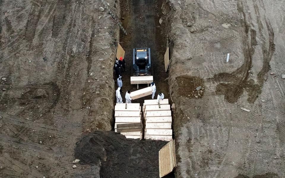 New York is still scarred by images of mass burials as the city was overwhelmed - John Minchillo/AP