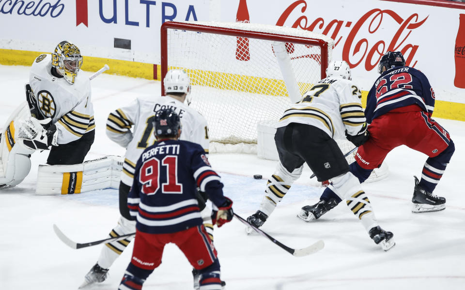 Winnipeg Jets' Nino Niederreiter (62) scores on Boston Bruins goaltender Jeremy Swayman, left, during the second period of an NHL hockey game Friday, Dec. 22, 2023, in Winnipeg, Manitoba. (John Woods/The Canadian Press via AP)