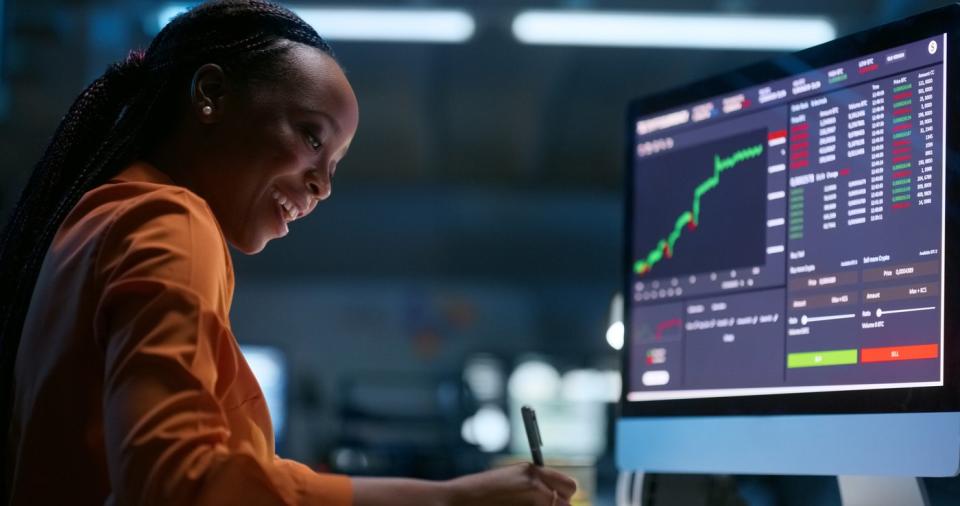 Young female investor in front of computer chart. 