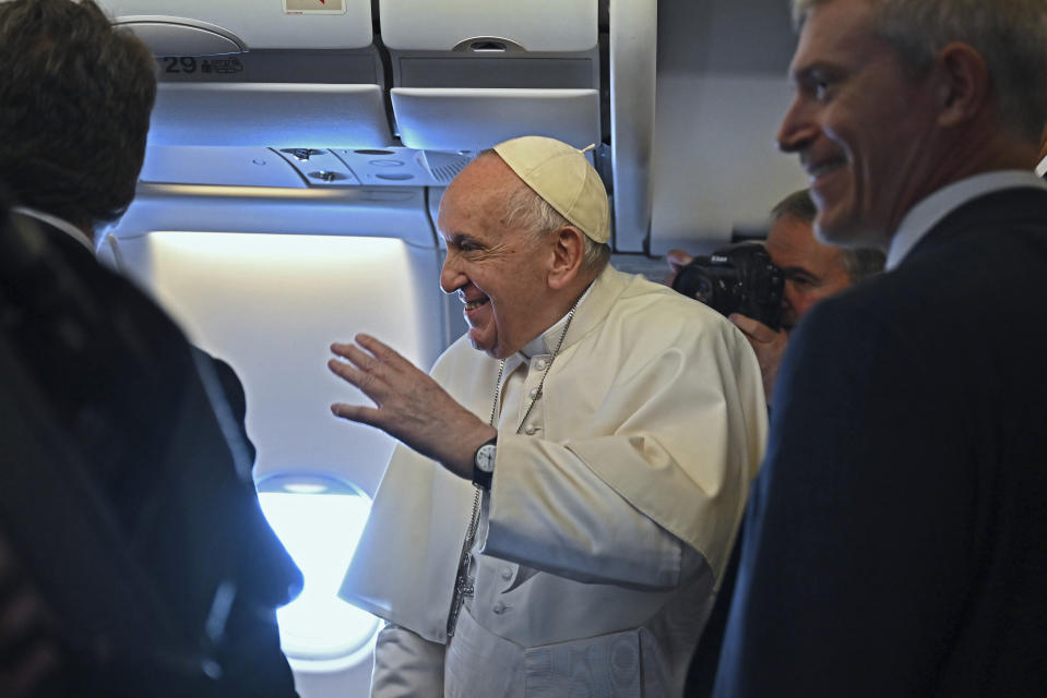 Pope Francis greets the journalists onboard the papal plane on the occasion of his four-day pastoral visit to Bahrain, Thursday, Nov. 3, 2022. Pope Francis is making the November 3-6 visit to participate in a government-sponsored conference on East-West dialogue and to minister to Bahrain's tiny Catholic community, part of his effort to pursue dialogue with the Muslim world. (Marco Bertorello/Pool Photo via AP)