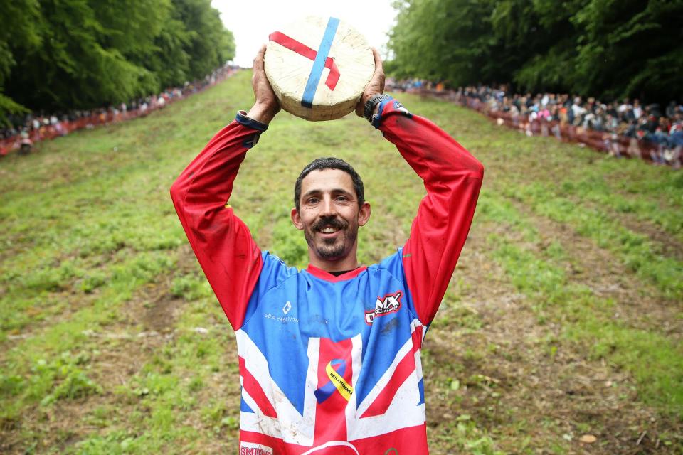 Chris Anderson poses for a photo with the cheese after winning the first man's downhill race on June 05, 2022 in Gloucester, England