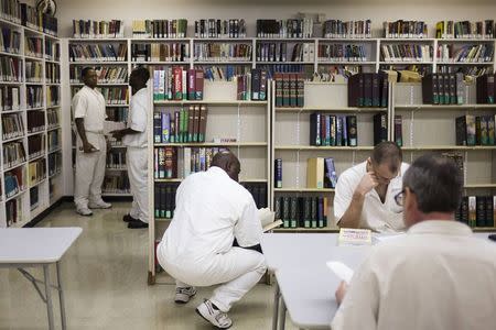 Offenders search for books and study at a library inside the Southwestern Baptist Theological Seminary located in the Darrington Unit of the Texas Department of Criminal Justice men's prison in Rosharon, Texas August 12, 2014. REUTERS/Adrees Latif