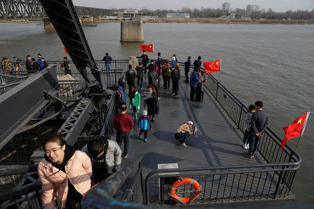 Tourists gather to watch North Korean side of the Yalu River from the Broken Bridge, bombed by the U.S. forces in the Korean War and now a tourist site, in Dandong, China's Liaoning province, April 1, 2017. REUTERS/Damir Sagolj