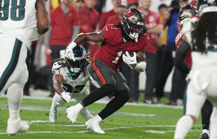 Tampa Bay running back Rachaad White outruns Philadelphia cornerback Bradley Roby during a playoff game