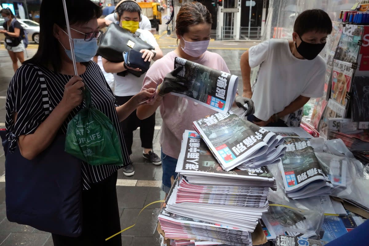 People queue up to buy last issue of Apple Daily at a newspaper booth at a downtown street in Hong Kong on 24 June 2021. Six former executives of Apple Daily pleaded guilty to a collusion charge (Associated Press)