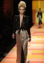 <b>Jean Paul Gaultier SS13 </b><br><br>Dresses featured gold sequins and black top half split to the navel.<br><br>© Rex