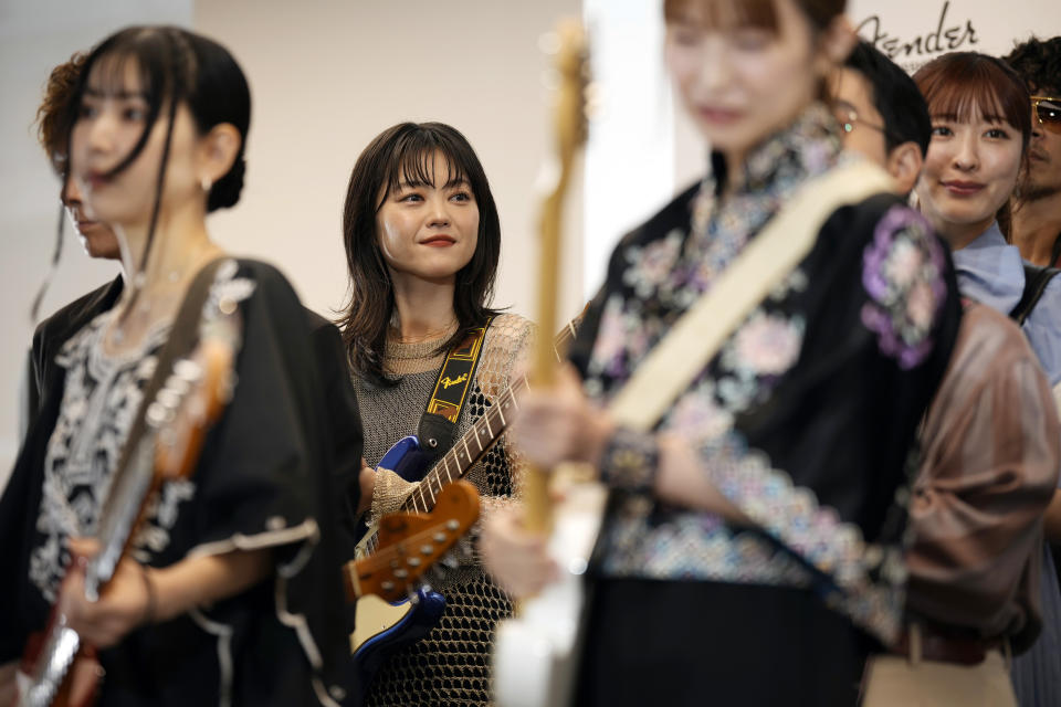 Erino Yumiki, center, a Japanese guitarist and songwriter, attends the opening ceremony of Fender's Tokyo store Thursday, June 29, 2023. Fender, the guitar of choice for some of the world’s biggest stars from Jimi Hendrix to Eric Clapton, is opening what it calls its “first flagship store” in its 77-year history. (AP Photo/Eugene Hoshiko)