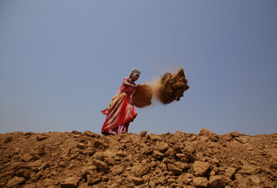 In this April 15, 2014 photo, Indian woman Shanti Patel helps dig a water reservoir at the edge of an open coal mine in Sarasmal village near the industrial city of Raigarh, in Chhattisgarh state, India. While India’s rapid economic growth over the past decade has boosted the incomes and living standards of millions - mostly city-dwellers - the environmental impact has often been ignored and the rural poor have been left behind. (AP Photo/Rafiq Maqbool)