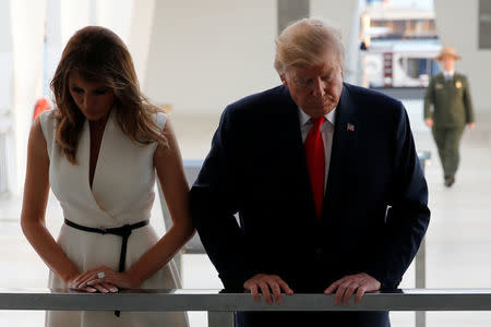 U.S. President Donald Trump and first lady Melania Trump look down into the water at the World War II wreckage of the USS Arizona, sunk during the attack on Pearl Harbor, at the Arizona Memorial in Honolulu, Hawaii, U.S. November 3, 2017. REUTERS/Jonathan Ernst