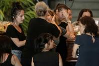 Relatives of victims comforted each other as they huddled around each of the 19 caskets