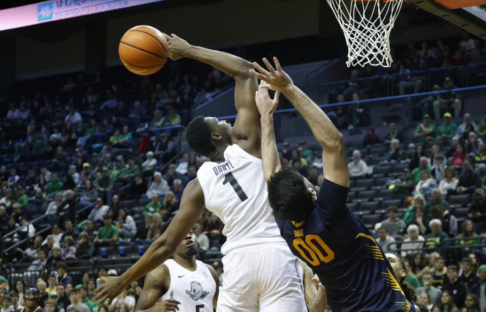 Oregon center N'Faly Dante (1) bats the ball away against from California forward Fardaws Aimaq (00) during the second half of an NCAA college basketball game in Eugene, Ore., Saturday, Jan. 13, 2024. (AP Photo/Thomas Boyd)