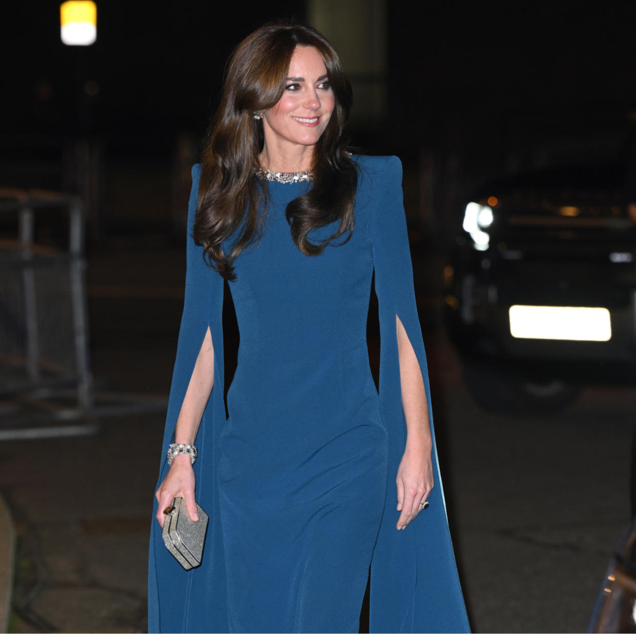  Kate Middleton in a blue cape dress and Meghan Markle in a blue cape dress. 