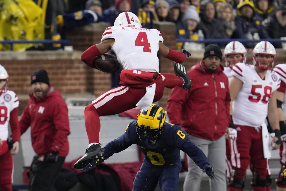 Nebraska wide receiver Alante Brown (4) tries to hurdle Michigan defensive back Mike Sainristil (0) in the first half of an NCAA college football game in Ann Arbor, Mich., Saturday, Nov. 12, 2022. (AP Photo/Paul Sancya)