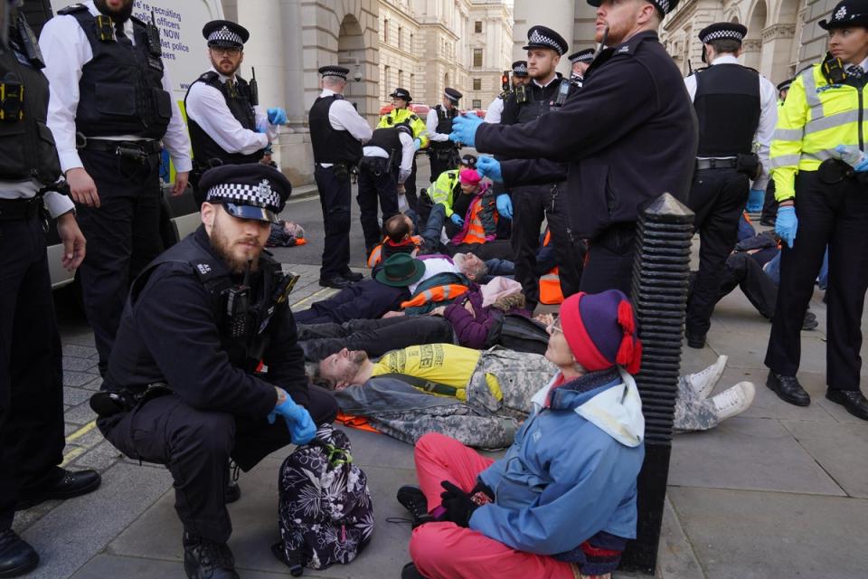 Officers from the Metropolitan Police surround Just Stop Oil protesters (Lucy North/PA Wire)